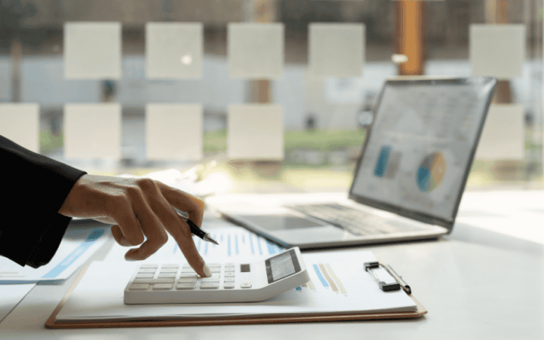 A person using a calculator on a desk - Catch Up Bookkeeping Services